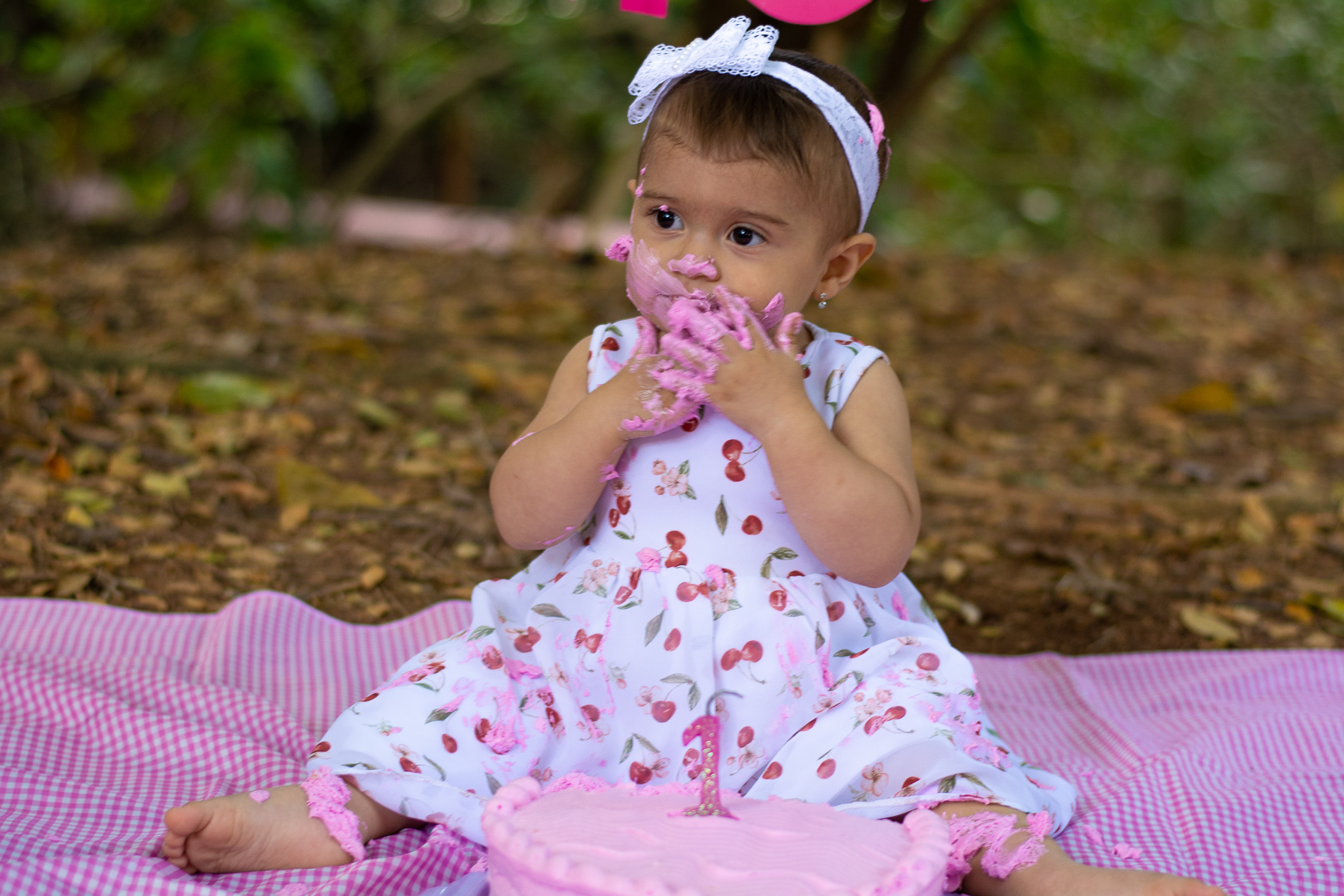 Menininha comendo um bolo rosa